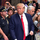 Donald Trump, probably being escorted to jail for crimes against spray-on bronzer (Credit: Getty Images)